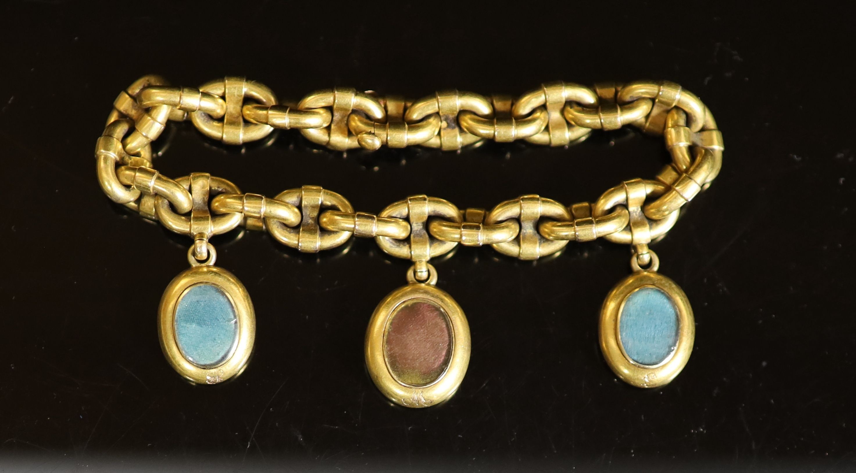 A Victorian gold oval link memorial bracelet, hung with three engraved oval charms, with glazed backs